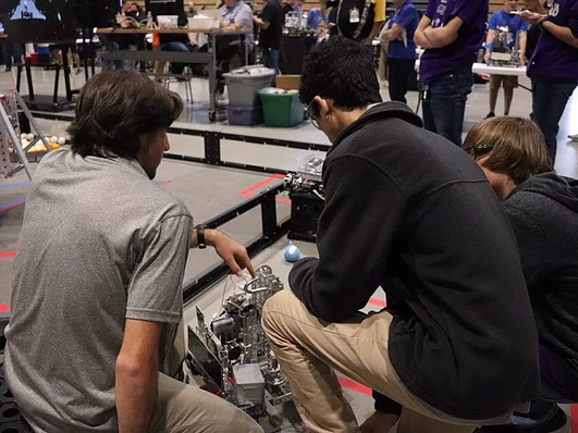 Members of Fortissimus inspect their robot after a match.